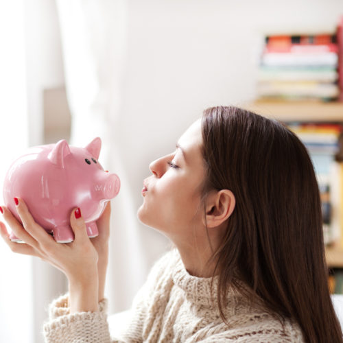 Woman kissing piggy bank